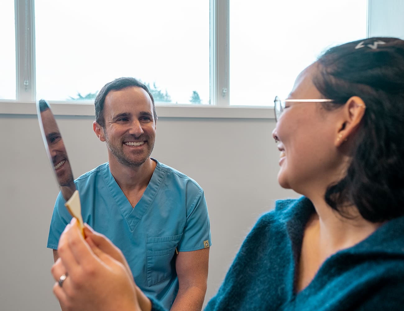 Dr. Epstein showing a patient the after result of a dental implant